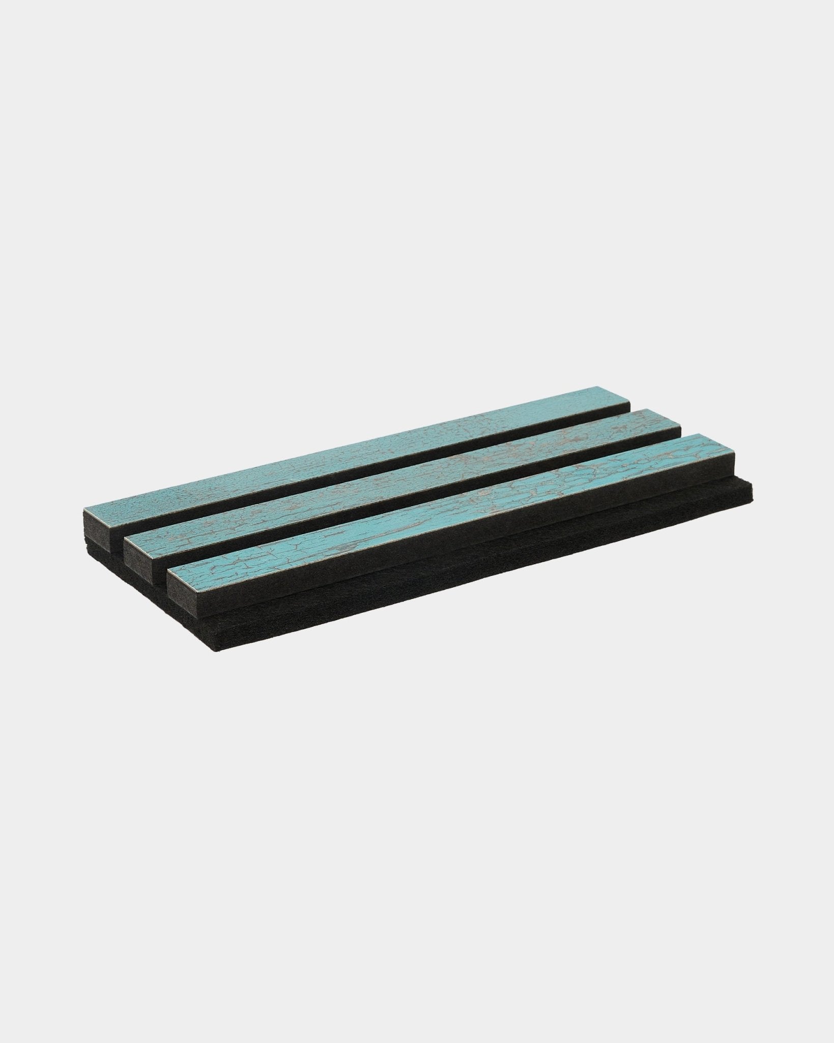 Drie Blue Oxide Rebel-foam pads van WoodUpp liggen parallel gestapeld op een strak, wit oppervlak; ontworpen als akoestische accessoires voor Scandinavische interieurs.